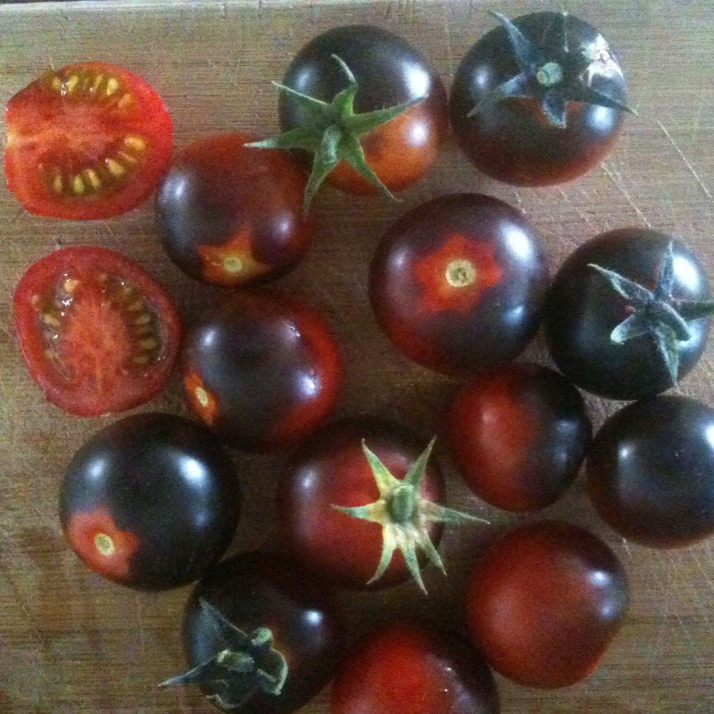 Un groupe de Tomate Bleue Cerise dansant avec les Schtroumpfs, connus sous le nom de cerises bleues, sur une planche à découper. (Nom de marque : Tourne-Sol)